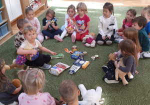 Dzieci siedzą na dywanie i rozmawiają na temat tego, jak dbać o psa