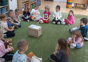 Dzieci siedzą w kole na dywanie