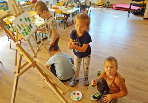Dzieci malują kropki farbami przy sztalugach