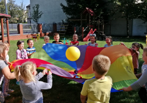 Zabawy dzieci w ogrodzie z chustą animacyjną