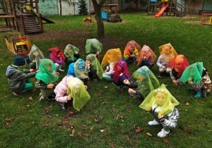 Dzieci kucają z kolorowymi chustami na głowie
