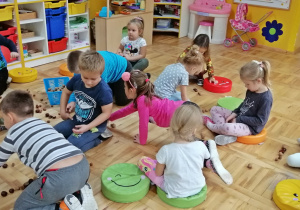 Dzieci układają kasztany na podłodze