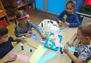 Dzieci wyklejają papierowe zakładki