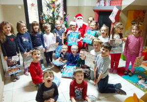 Dzieci pozują do zdjęcia ze Świętym Mikołajem