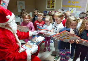 Dzieci oglądają prezenty od Świętego Mikołaja
