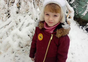 Dziewczynka w ogrodzie przedszkolnym w zimowej aurze