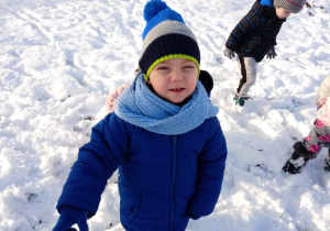 Chłopiec stoi na śniegu