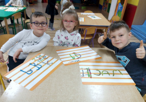 Dzieci prezentują wyklejone napisy z plasteliny