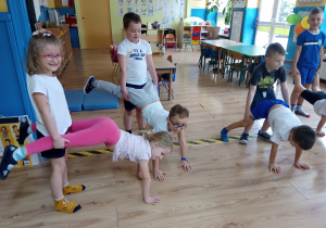 Dzieci ćwiczą gimnastycznie w parach