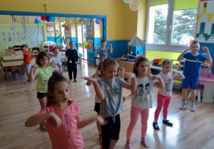 Dzieci powtarzają ćwiczenia gimnastyczne
