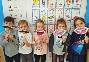 Dzieci przymierzają sztuczne usta i wąsy