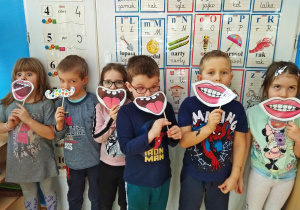 Dzieci przymierzają sztuczne usta i wąsy