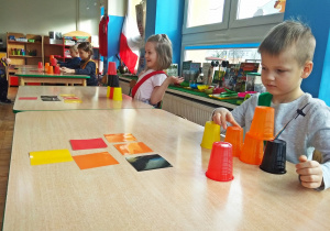 Dzieci układają wieżę z kubków