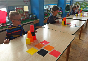 Dzieci układają wieżę z kubków