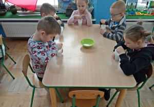 Dzieci mieszają sól z wodą w kubeczku