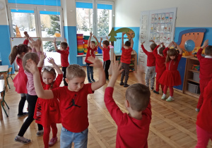 Dzieci tańczą z rękoma w górze