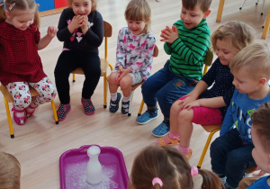 Dzieci oglądają eksperyment z sodą i octem