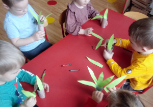Dzieci wykonują elementy makiety dinozaurów