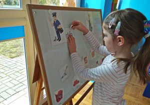 Dziewczyna uklada obrazki na tablicy