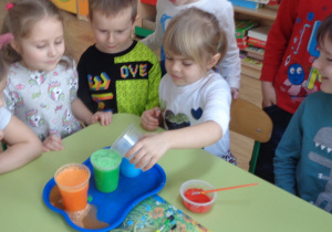 Dziewczynka wsypuje do wody kwasek cytrynowy