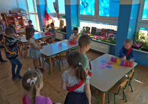 Dzieci układają piramidę z kubków zgodnie z podanym wzorem