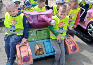 Chłopcy z grupy 6-latków próbuja odpalić czołg-zabawkę