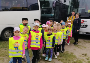 Dzieci pozują do zdjęcia przed autokarem
