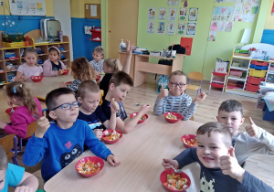 Chłopcy jedzą sałatkę owocową