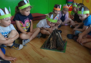 Chłopiec dmucha na model ogniska