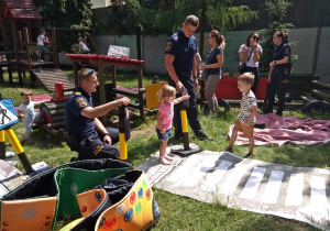 Dzieci ćwiczą prawidło przechodzić po pasach na macie dydaktycznej