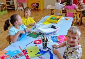 Dzieci rysują i wycinają przy stoliku