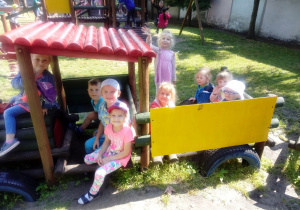 Przedszkolaki bawią się w drewnianej ciuchci