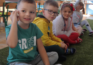 Dziecko przykłada muszlę do ucha