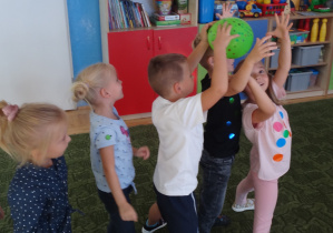 Dzieci podają sobie balon nad głową