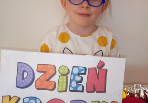 Dziewczynka pozuje do zdjęcia z napisem Dzień Kropki