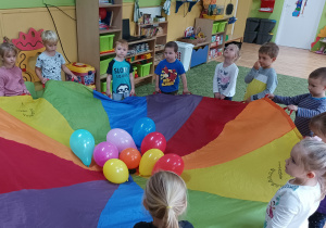 Dzieci nawią się chustą animacyjną i balonami
