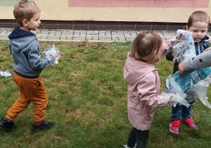 Dzieci sprzątają w ogrodzie przedszkolnym
