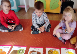 Dzieci oglądają ilustracje z owocami