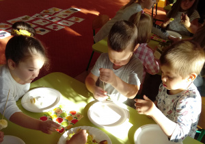 Dzieci wykonują szaszłyki z owoców