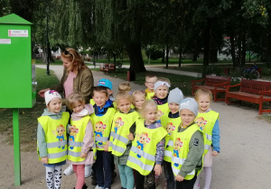 Dzieci pozują do zdjęcia obok skrzynki z jedzeniem dla kaczek
