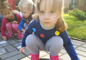 Dzieci rysują kredą na chodniku
