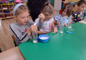 Dzieci wsypują sodę do butelki