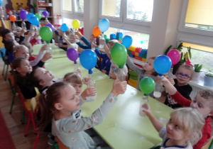 Dzieci prezentują balony nadmuchane octem z sodą