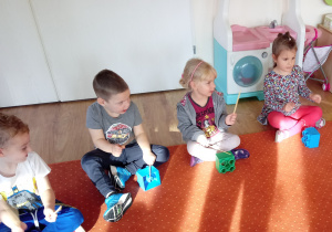 Dzieci grają uderzając patyczkami o klocki