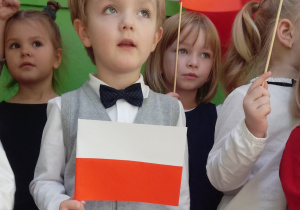 Chłopiec śpiewa hymn narodowy "Mazurek Dąbrowskiego"