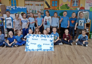 Dzieci pozują do zdjęcia z plakatem