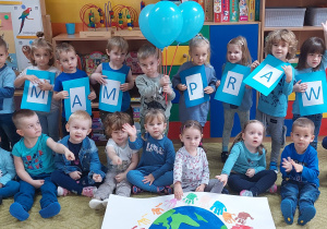 Dzieci pozują z plakatem i hasłem Mam prawo