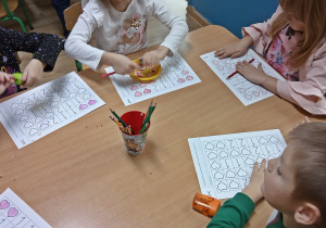 Dzieci rozwiązują zadania na kartce