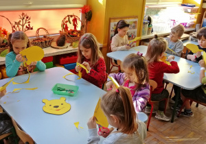 Dzieci wycinają sylwetę głowy Kubusia Puchatka