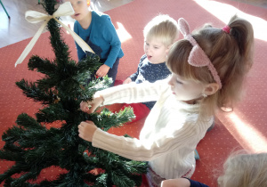 Dziewczynka wiesza ozdobę choinkową